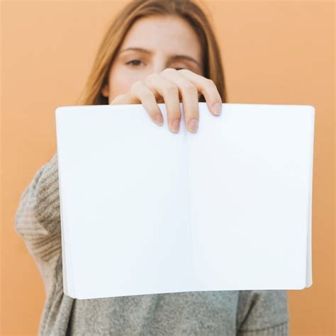 Free Photo Young Woman Holding An Open White Book In Front Of Camera