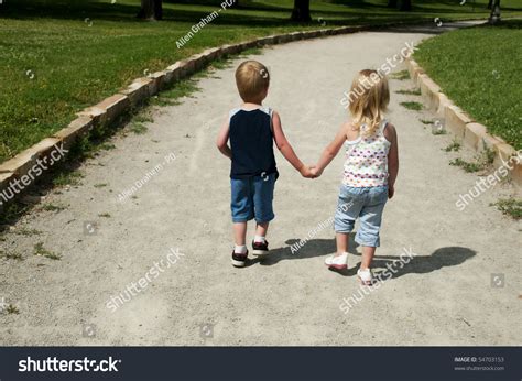 Стоковая фотография 54703153 Two Young Children Holding Hands Walking