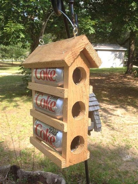 A Bird House Made Out Of Wood And Cans Hanging From Its Side In The Yard
