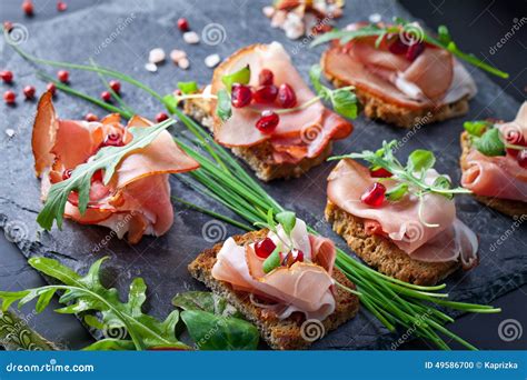 Sliced Prosciutto With Herbs And Pomegranate Seeds Stock Photo Image