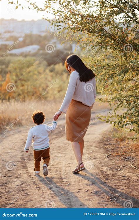 mom and her little son 2 years old on walk in the autumn park holding hands motherhood mothers
