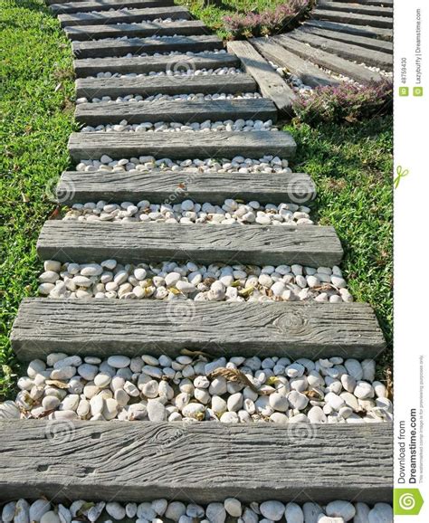Wood And Small White Rocks Pathway On Grass In The Garden Stock
