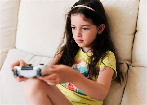 Vista lateral niña jugando videojuegos con controlador Foto Gratis