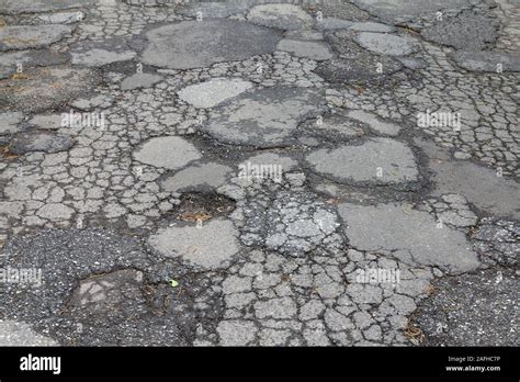 Road Damage In Japan Cracked Asphalt Blacktop With Potholes And