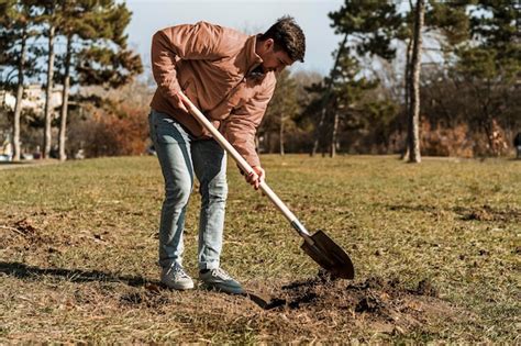 Free Photo Side View Of Man Using Shovel To Dig A Hole For Planting A