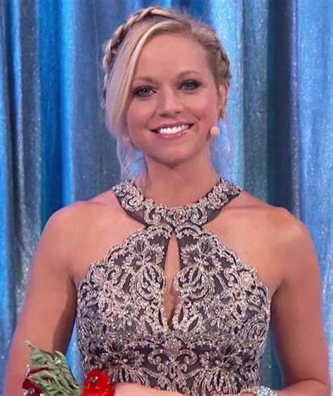A Woman In A Black And White Dress Holding A Bouquet Of Flowers On The Set Of Dancing With The Stars