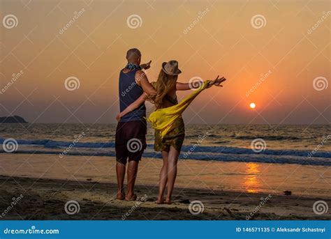 Lovers Hugging Against Sunset On The Sea Young Couple Standing On A Beach And Admiring To
