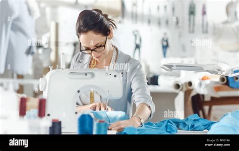 Female Fashion Designer Seamstress Dressmaker Working On A Sewing Machine In Her Sunny