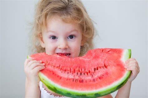Cute Little Baby Girl Eating Watermelon Slice On Light Background Stock