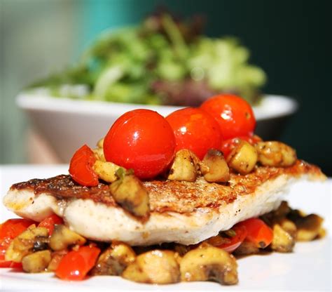 Sea Bass With Roasted Spicy Cherry Tomatoes Mushrooms In Saffron And Garlic Ginger