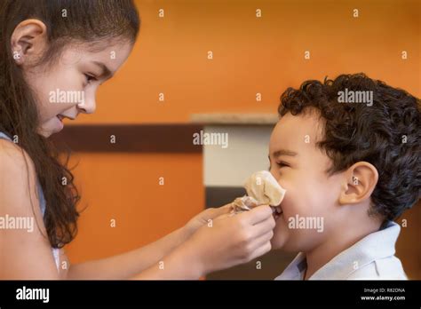 Big Sister Helps Little Brother Blow His Nose Older Sister Focused On