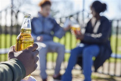 Close Up Of Underage Teenagers Drinking Alcohol In Park Renna Media