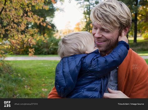 Father And Son Hugging In Park Stock Photo Offset