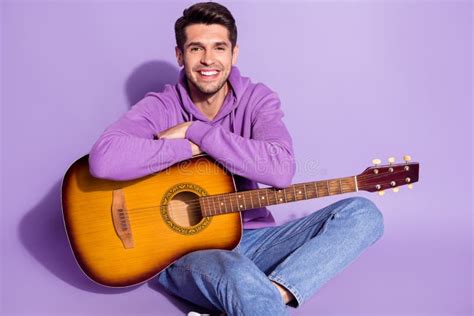 Portrait Of Attractive Cheerful Guy Sitting Playing String Guitar