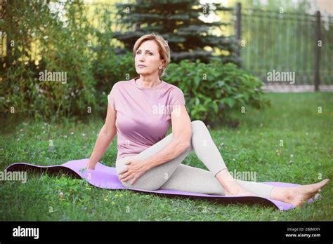 Beautiful Mature Woman Practicing Yoga In Park Stock Photo Alamy