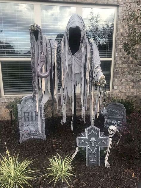 Halloween Decorations In Front Of A House With Fake Skeletons And
