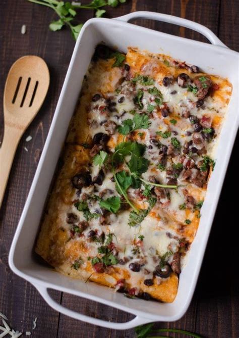 This ground beef enchilada recipe is filled with grass fed ground beef, sautéed chopped yellow onions, pinto beans, enchilada sauce, freshly shredded cheddar cheese and topped off with sliced olives and chopped spring onions. Ground Beef Enchiladas Recipe | FaveHealthyRecipes.com