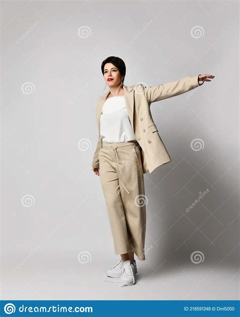 Adult Pretty Brunette Woman Walks In Beige Business Smart Casual Pantsuit And Sneakers Stylish