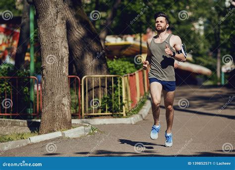 A Male Runner Runs Along The Road To The Park Stock Image Image Of