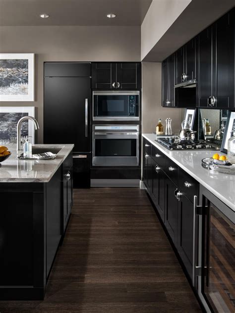 Black wood floors clad with a herringbone pattern mixed with dark cabinets polished black lamitate flooring complement the design of this art deco kitchen 25+ Dark Kitchen Cabinets to Inspire