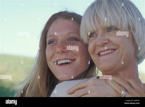 Portrait Of 57 Year Old Caucasian Woman With 22 Year Old Daughter Hugging Her Mother From Behind