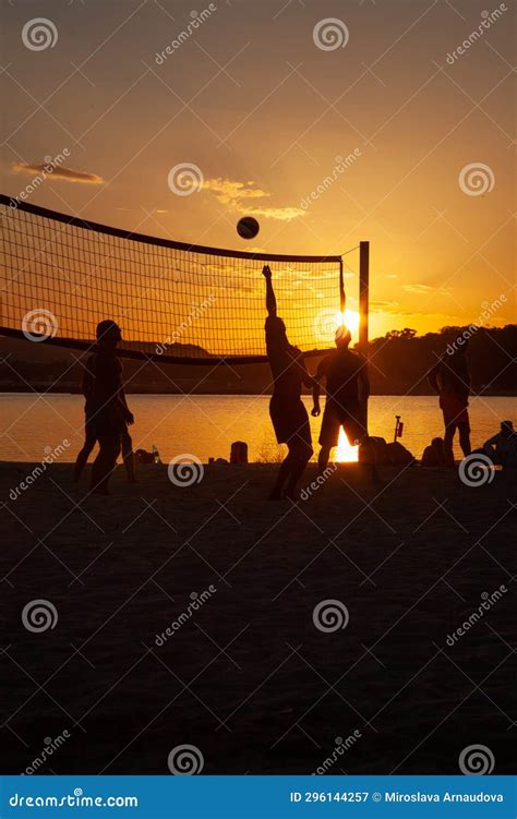 People Play Volleyball On The Beach During The Sunset Editorial