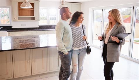 Female Realtor Showing Couple Interested In Buying Around House — Rismedia