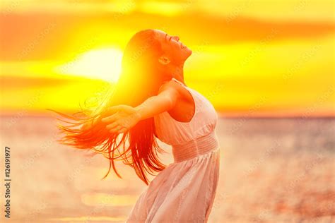Happy Woman Feeling Free With Open Arms In Sunshine At Beach Sunset