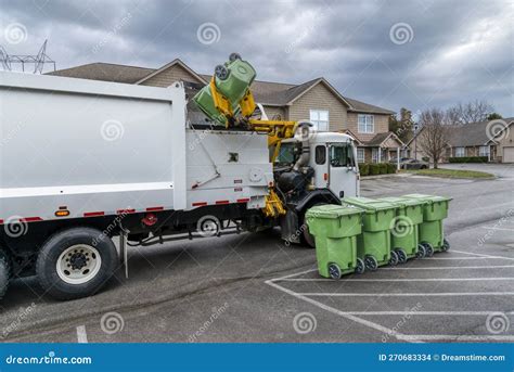 Garbage Truck Picking Up And Dumping Residential Trash Containers Stock
