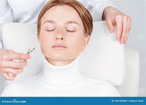Beautiful Woman Having Face Treatment Cosmetologist Massaging Face With Jade Rollers Stock