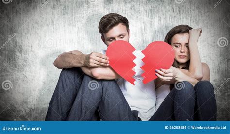 Composite Image Of Young Couple Holding Broken Heart Stock Photo