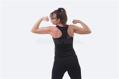 Attractive Middle Aged Woman In Sports Gear With Back To Camera Flexing