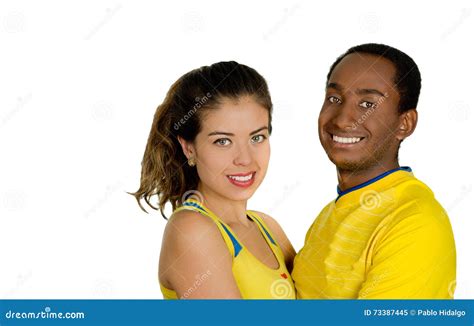 Charming Interracial Couple Wearing Yellow Football Shirts Embracing Friendly While Posing For