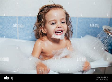 Beautiful Little Girl Taking A Bath At Home A Cute Baby Is Sitting In