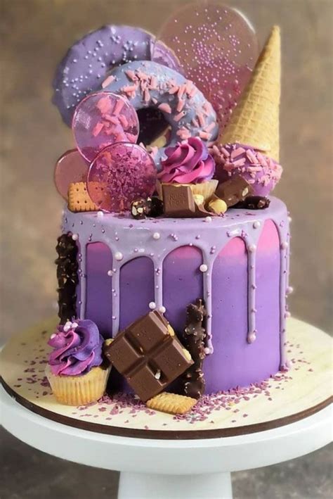 The Cake Is Decorated With Purple Icing And Lots Of Different Things On