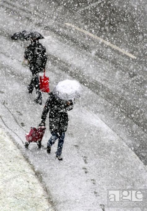 Two Persons Passing Each Other On The Street In Heavy Snowfall Winter