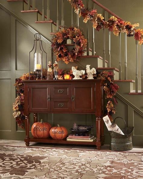An Entryway Decorated For Fall With Pumpkins And Wreaths On The Sideboard