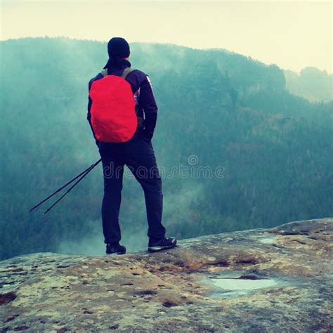 Hiker With Red Backpack On Sharp Sandstone Rock In Rock Empires Park And Watching Over The Misty