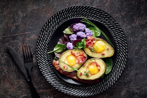 Aguacate Al Horno Con Huevo Y Tocino Plano Sobre Pared Oscura Foto Premium