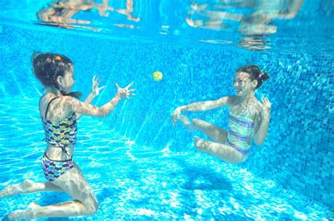 Children Swim In Pool Underwater Happy Active Girls Have Fun Under