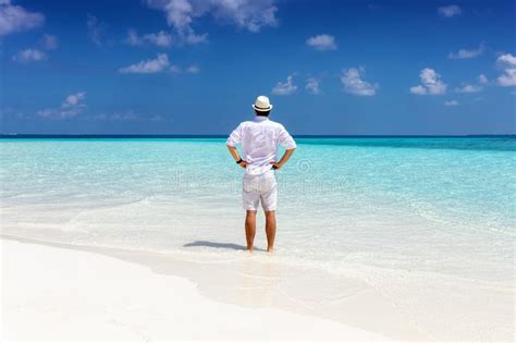 Man Stands On A Tropical Beach And Enjoys His Summer Stock Image
