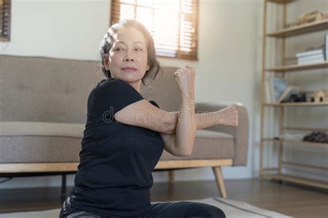 Portrait Of Mature Woman Doing Stretching Yoga Side Bend Exercise And Stretching Concept Stock