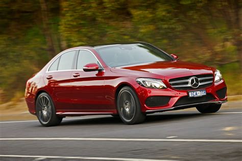 A Red Mercedes C Class Driving Down The Road