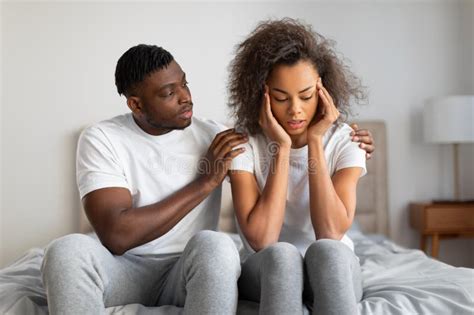 supportive millennial black husband comforting and supporting depressed wife indoor stock image