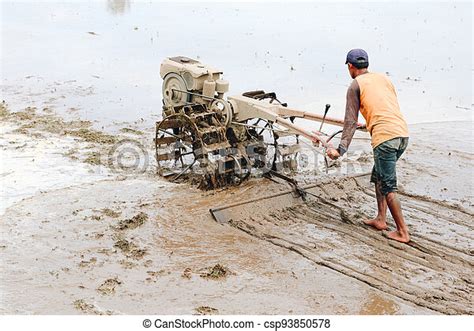 Indonesia Farmer Plowing A Rice Field Using Tiller Tractor Canstock