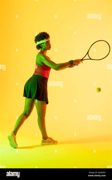 Vertical Image Of African American Female Tennis Player Hitting Ball In