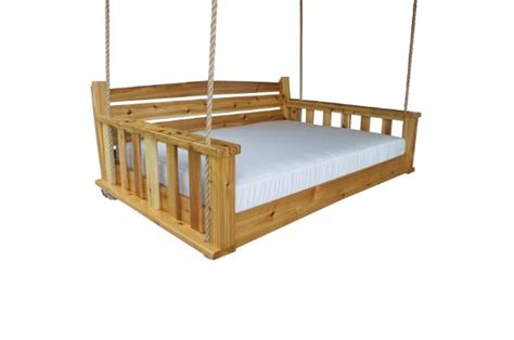 A Wooden Swing Bed With White Sheets On It