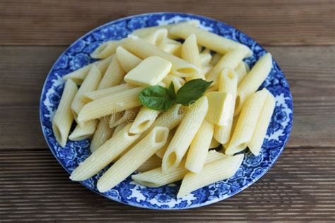 Cooked Penne Pasta With Butter And Cheese And Basil In Vintage