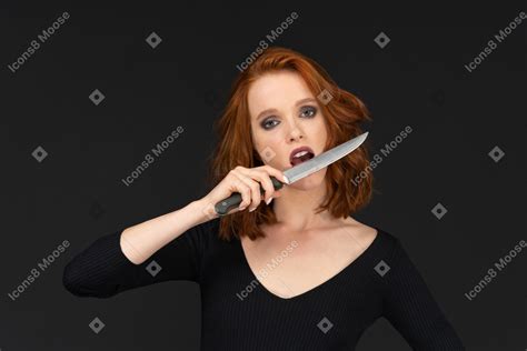 A Sexy Woman Posing And Holding A Knife Near Her Mouth のフォト