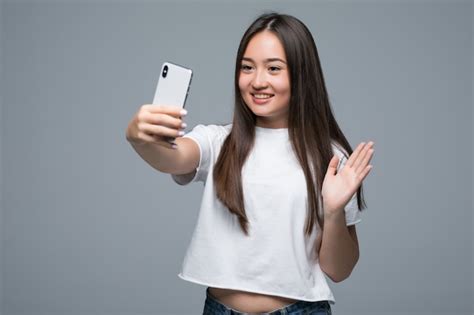 Mujer Asiática Joven Sonriente Que Toma Un Selfie Con El Teléfono Móvil Sobre Fondo Gris Aislado